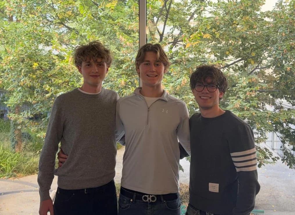 Oliver, Jonathan und Anton, die drei Schüler hinter Studytab, vor einem Fenster zum begrünten Innenhof ihrer Schule